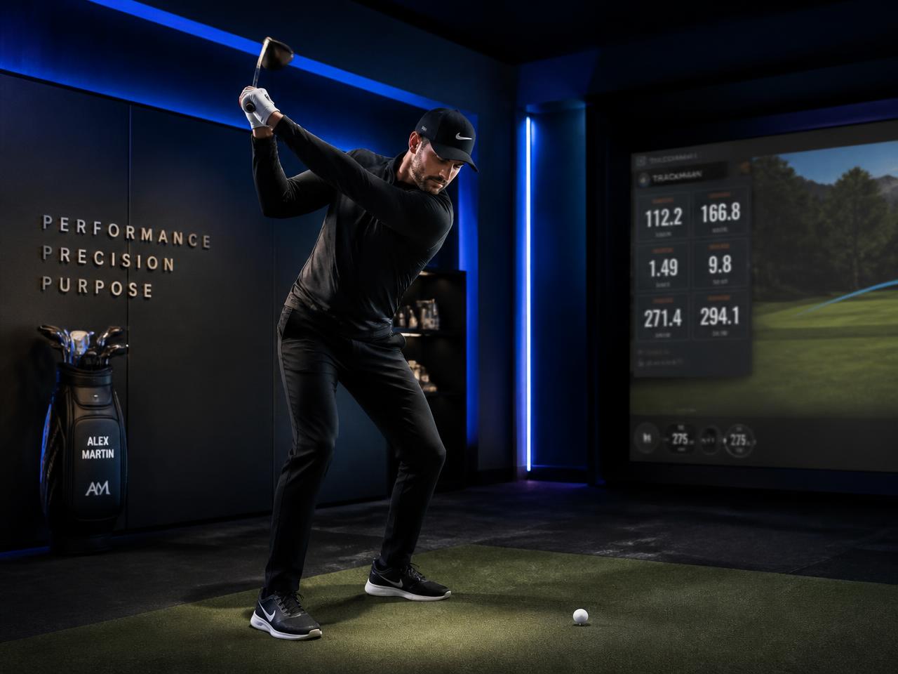 Golfer mid backswing in a high-end indoor golf performance studio